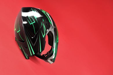 Modern motorcycle helmet with visor on red background. Space for text