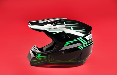 Photo of Modern motorcycle helmet with visor on red background