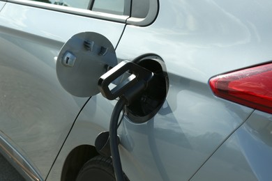 Photo of Charging modern electric car from station outdoors