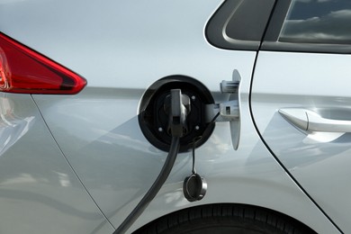 Photo of Charging modern electric car from station outdoors