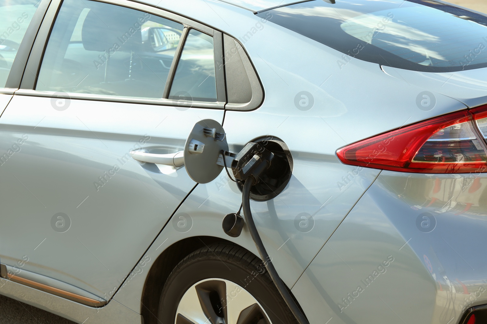 Photo of Charging modern electric car from station outdoors