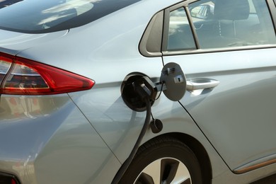 Charging modern electric car from station outdoors