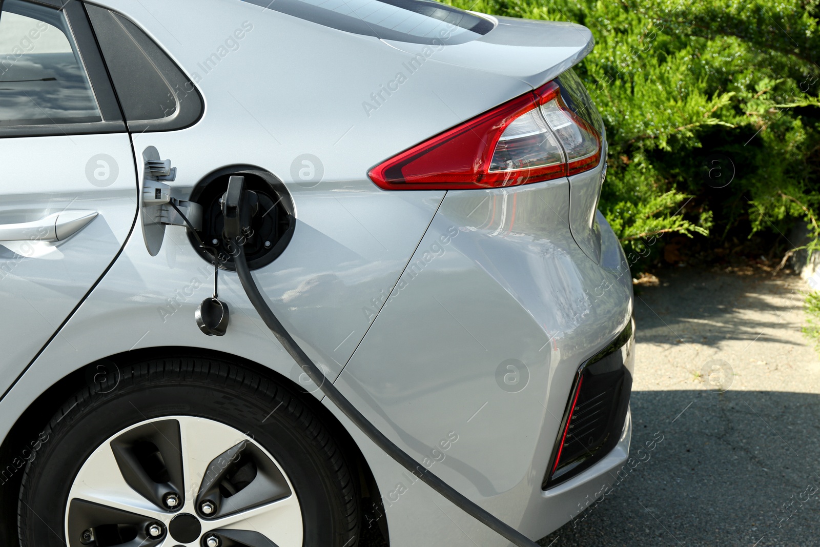 Photo of Charging modern electric car from station outdoors