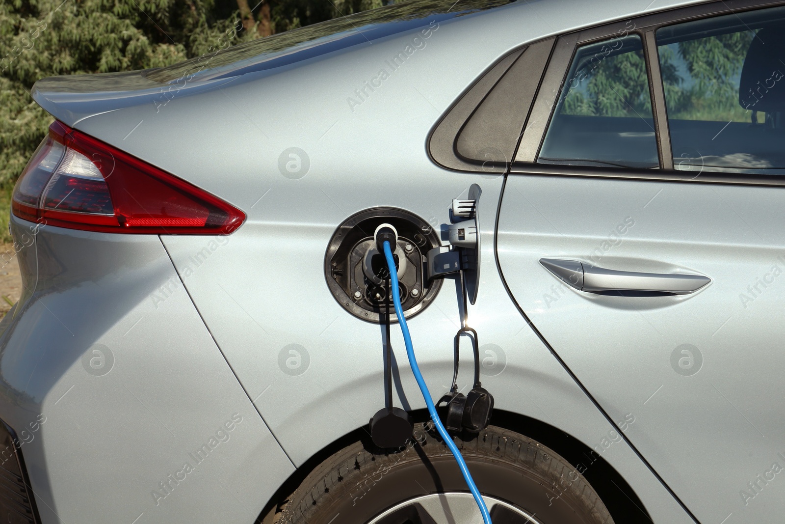 Photo of Charging modern electric car from station outdoors