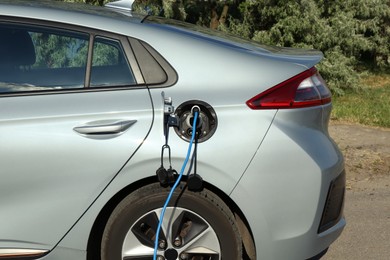 Charging modern electric car from station outdoors