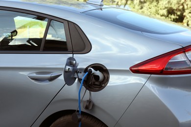 Charging modern electric car from station outdoors