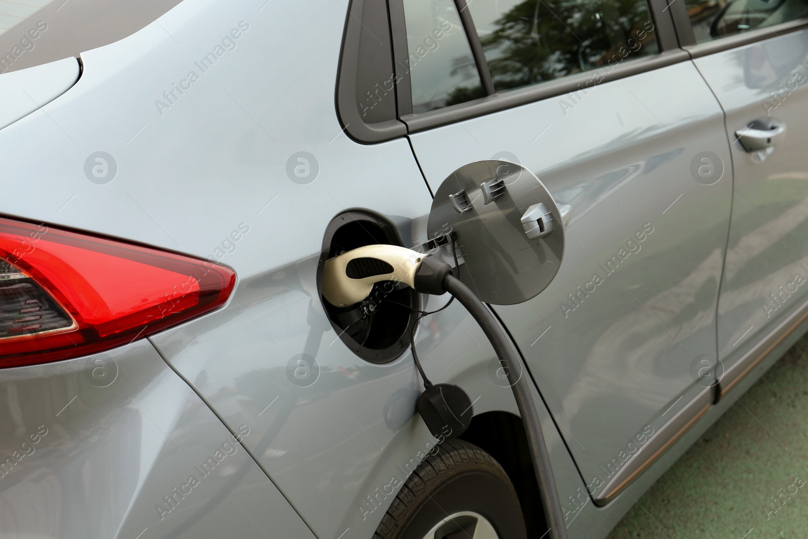 Photo of Modern electric car charging from station outdoors