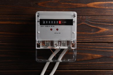 Photo of Electric meter on wooden wall. Energy measuring device