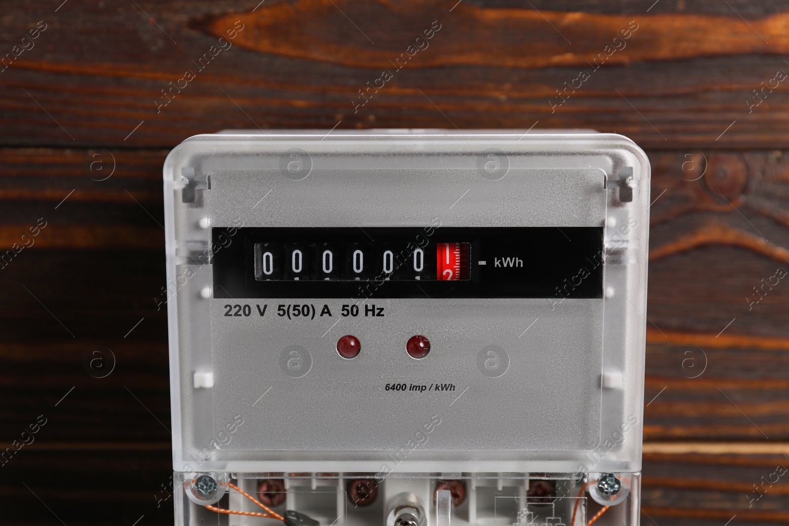 Photo of Electric meter on wooden wall. Energy measuring device