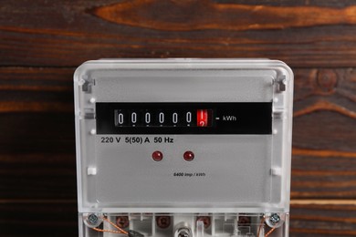 Photo of Electric meter on wooden wall. Energy measuring device