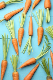 Tasty ripe juicy carrots on light blue wooden table, top view