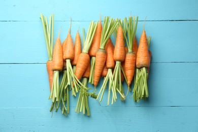 Tasty ripe juicy carrots on light blue wooden table, top view