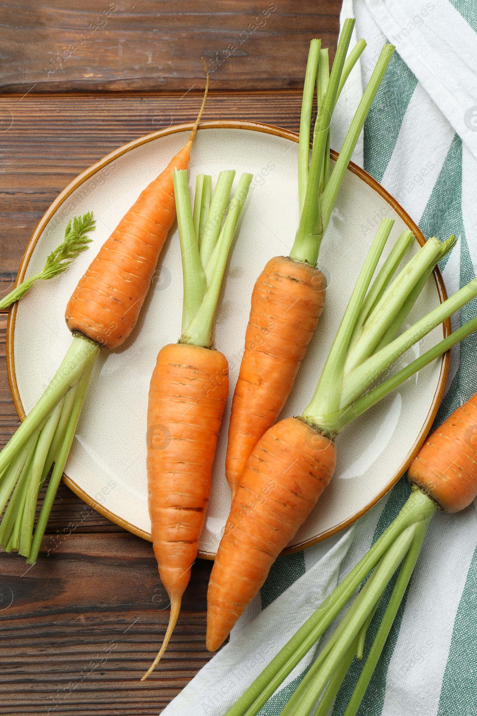 Photo of Tasty ripe juicy carrots on wooden table, top view