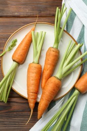 Tasty ripe juicy carrots on wooden table, top view