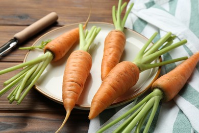 Photo of Tasty ripe juicy carrots on wooden table, closeup