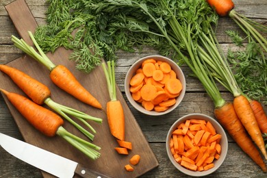 Photo of Fresh carrots and knife on wooden table, flat lay