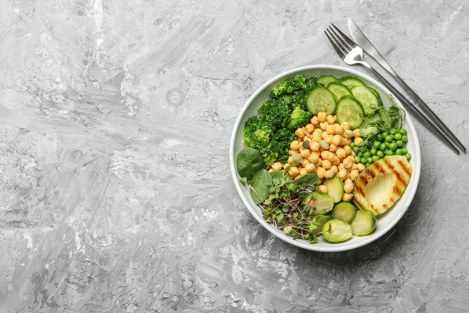 Photo of Healthy meal. Tasty vegetables and chickpeas in bowl on grey table, top view. Space for text