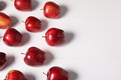 Photo of Fresh red apples on white wooden table. Space for text