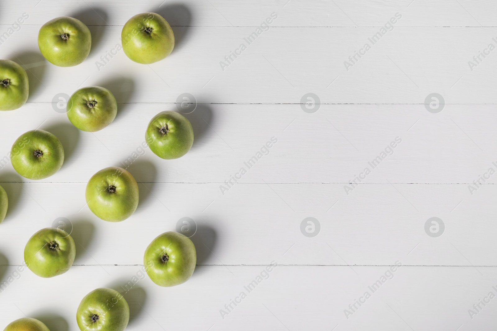 Photo of Fresh ripe green apples on white wooden table, flat lay. Space for text