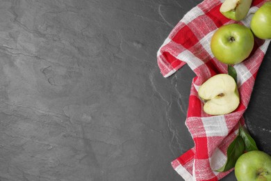 Photo of Whole and cut green apples on dark grey table, flat lay. Space for text