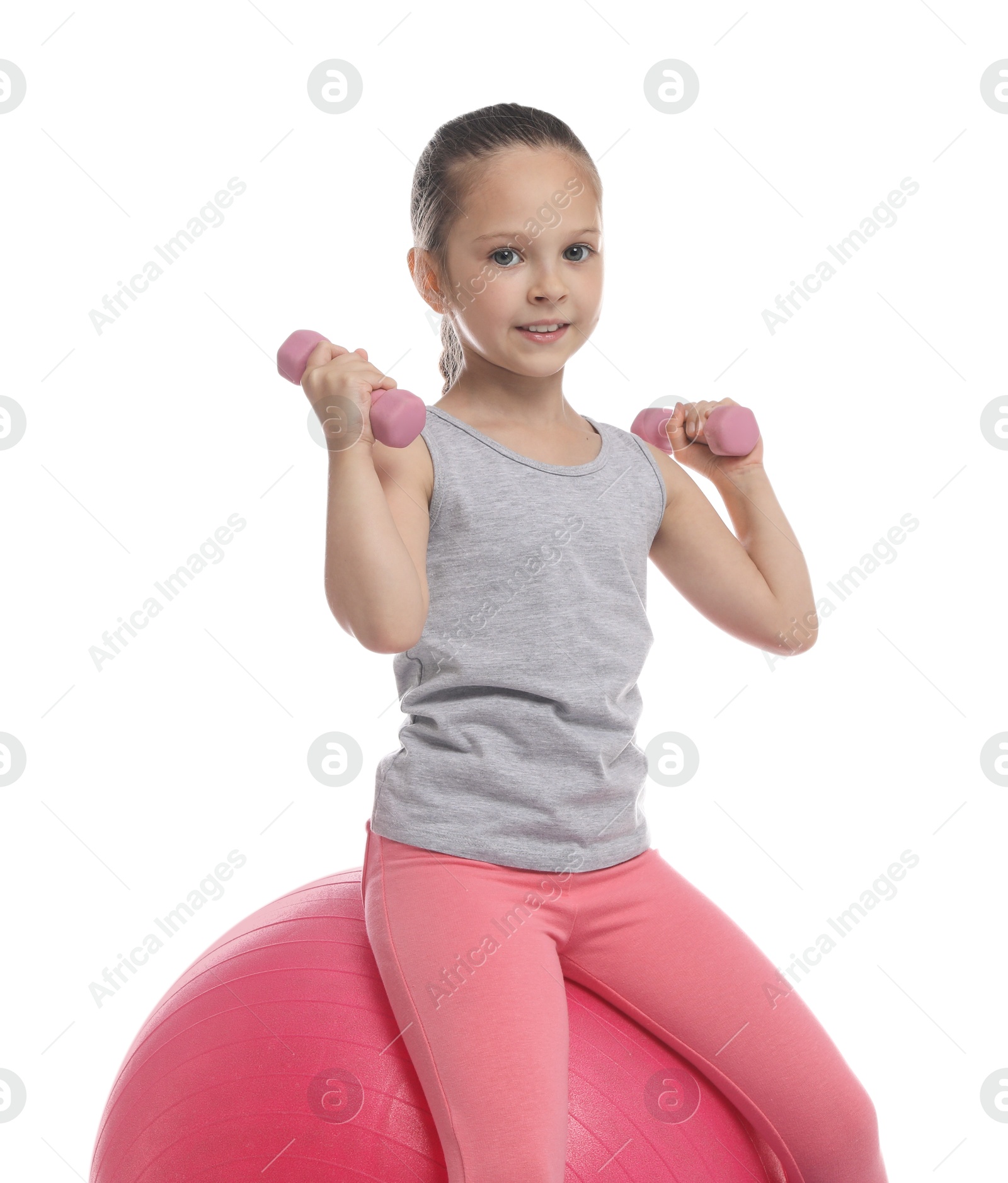 Photo of Cute little girl with dumbbells and fit ball on white background