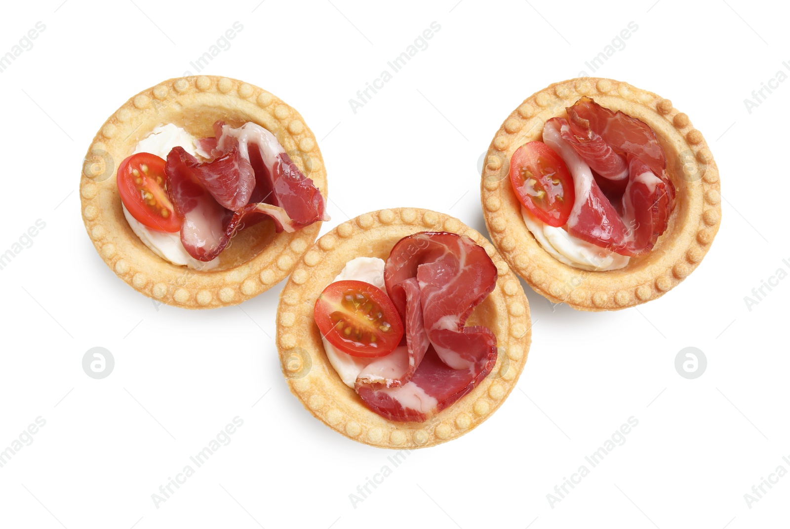 Photo of Delicious canapes with jamon, cream cheese and cherry tomatoes isolated on white, top view