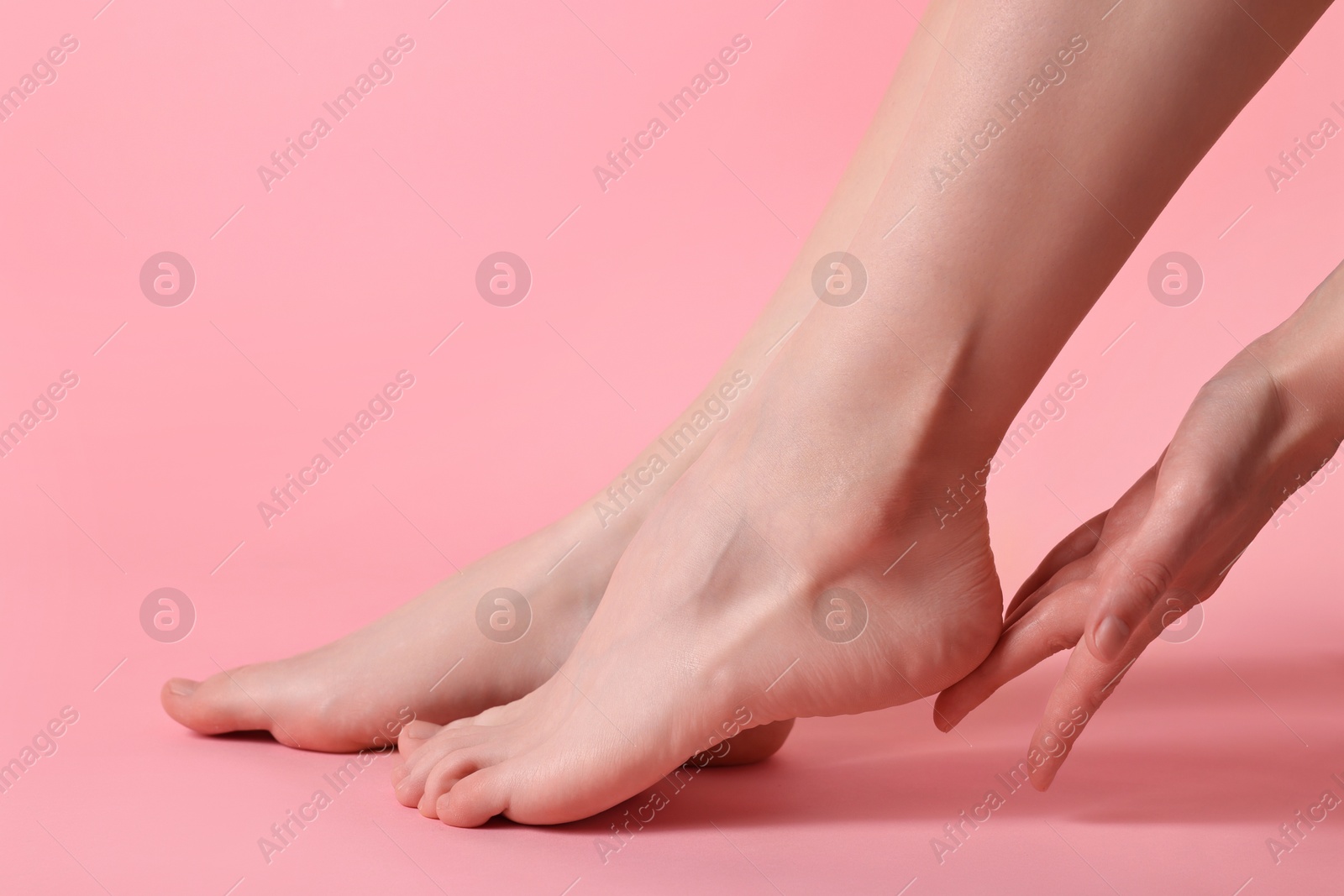 Photo of Closeup view of woman`s groomed feet after care procedure on pink background