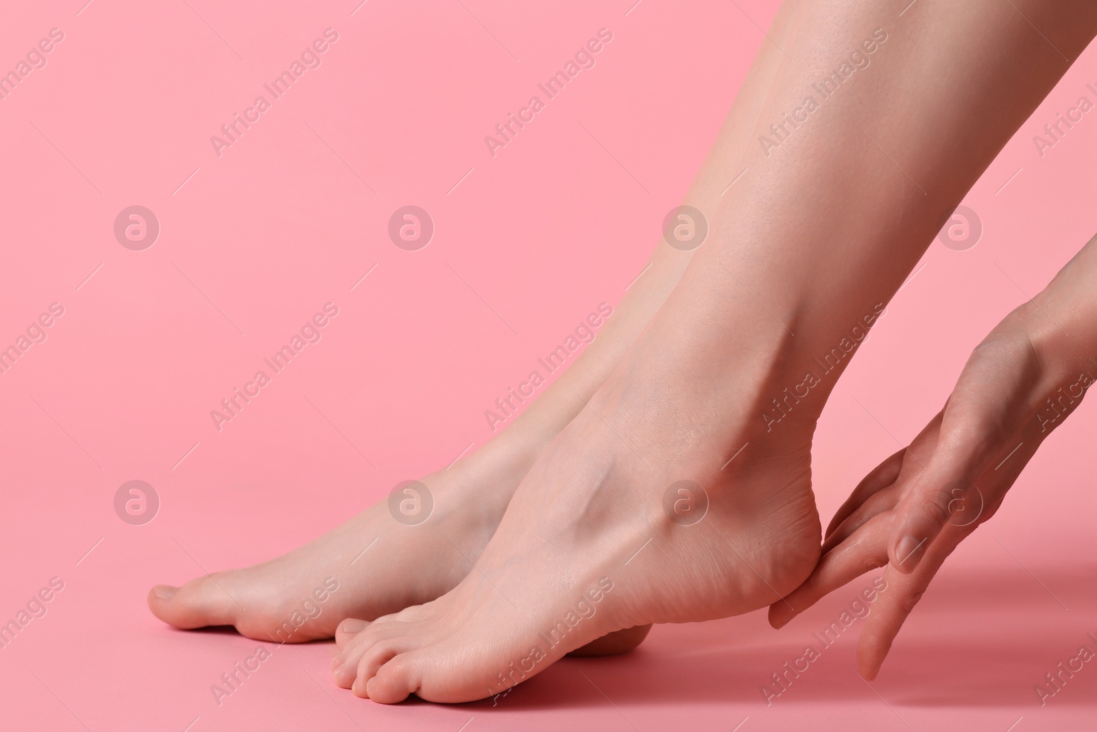 Photo of Closeup view of woman`s groomed feet after care procedure on pink background