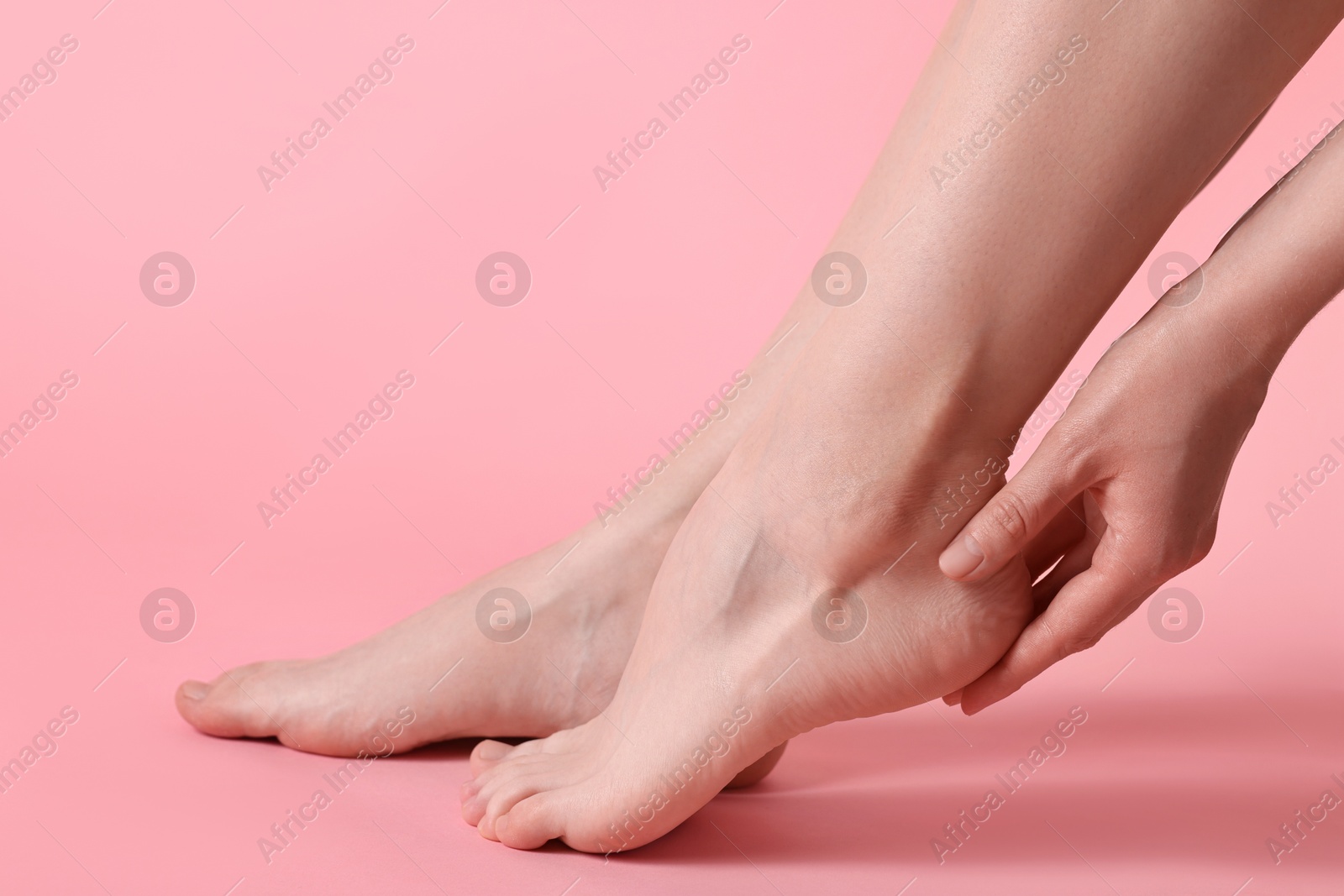 Photo of Closeup view of woman`s groomed feet after care procedure on pink background