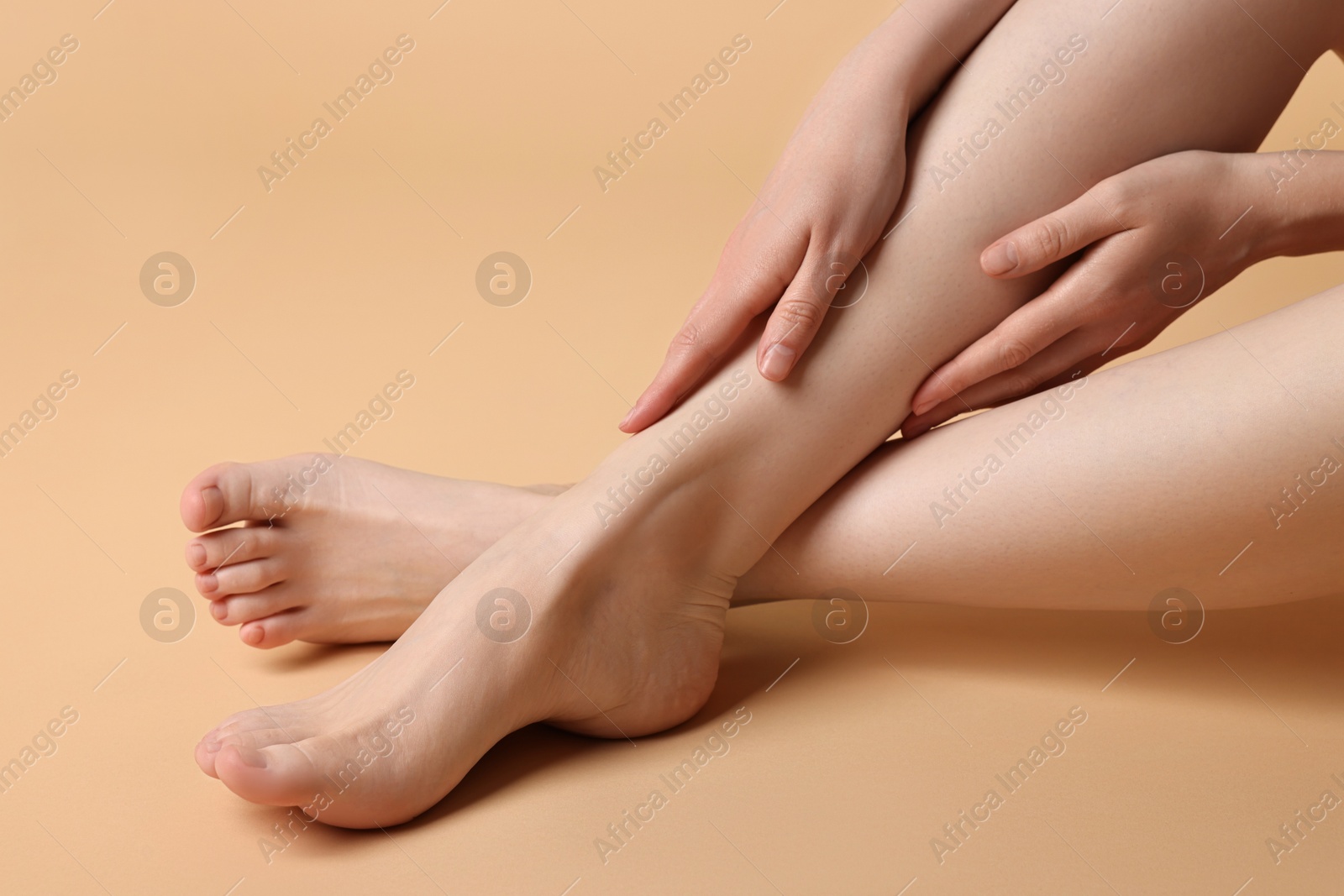 Photo of Closeup view of woman`s groomed feet after care procedure on beige background