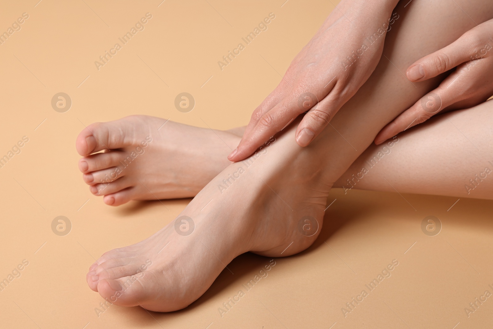 Photo of Closeup view of woman`s groomed feet after care procedure on beige background