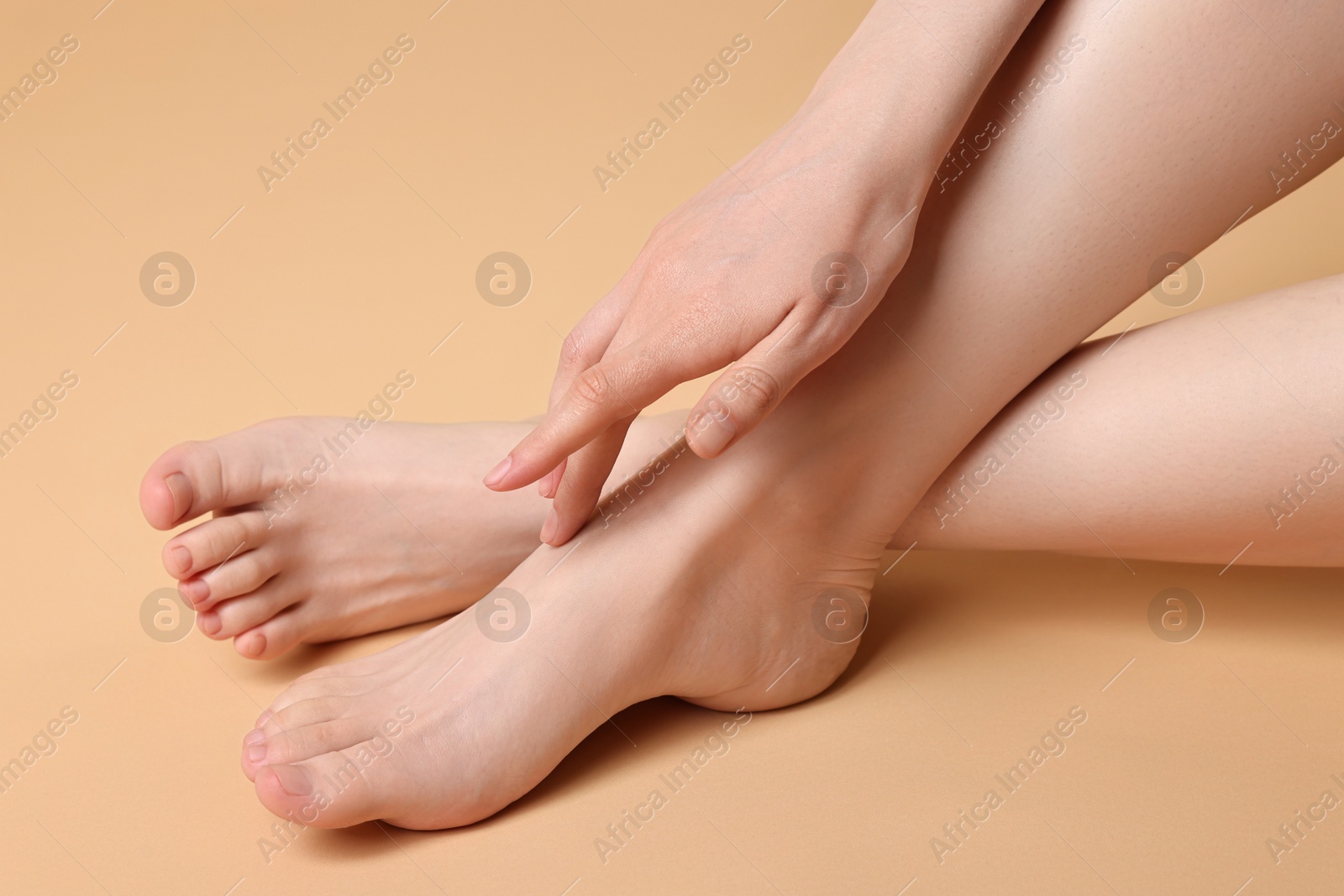 Photo of Closeup view of woman`s groomed feet after care procedure on beige background