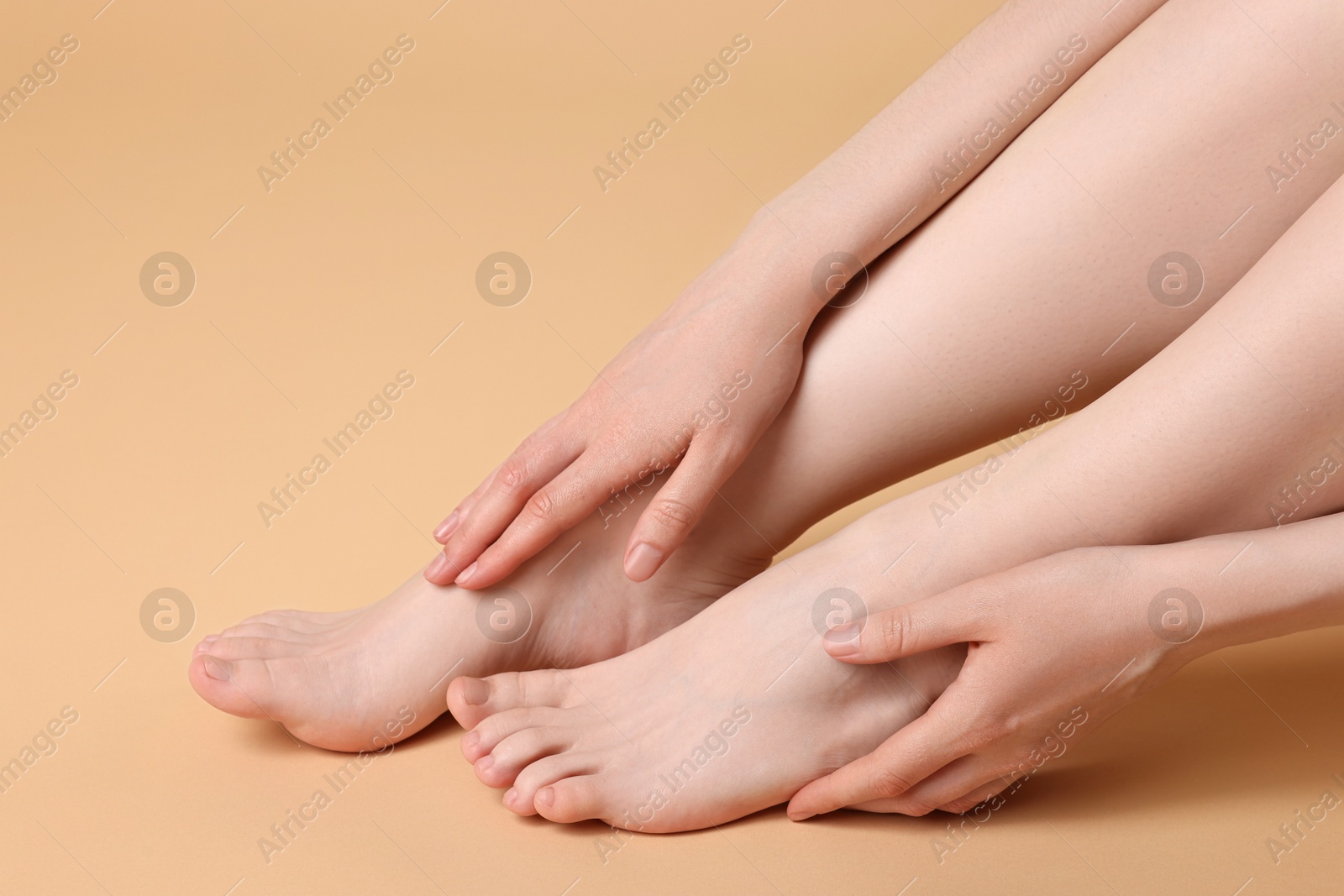 Photo of Closeup view of woman`s groomed feet after care procedure on beige background