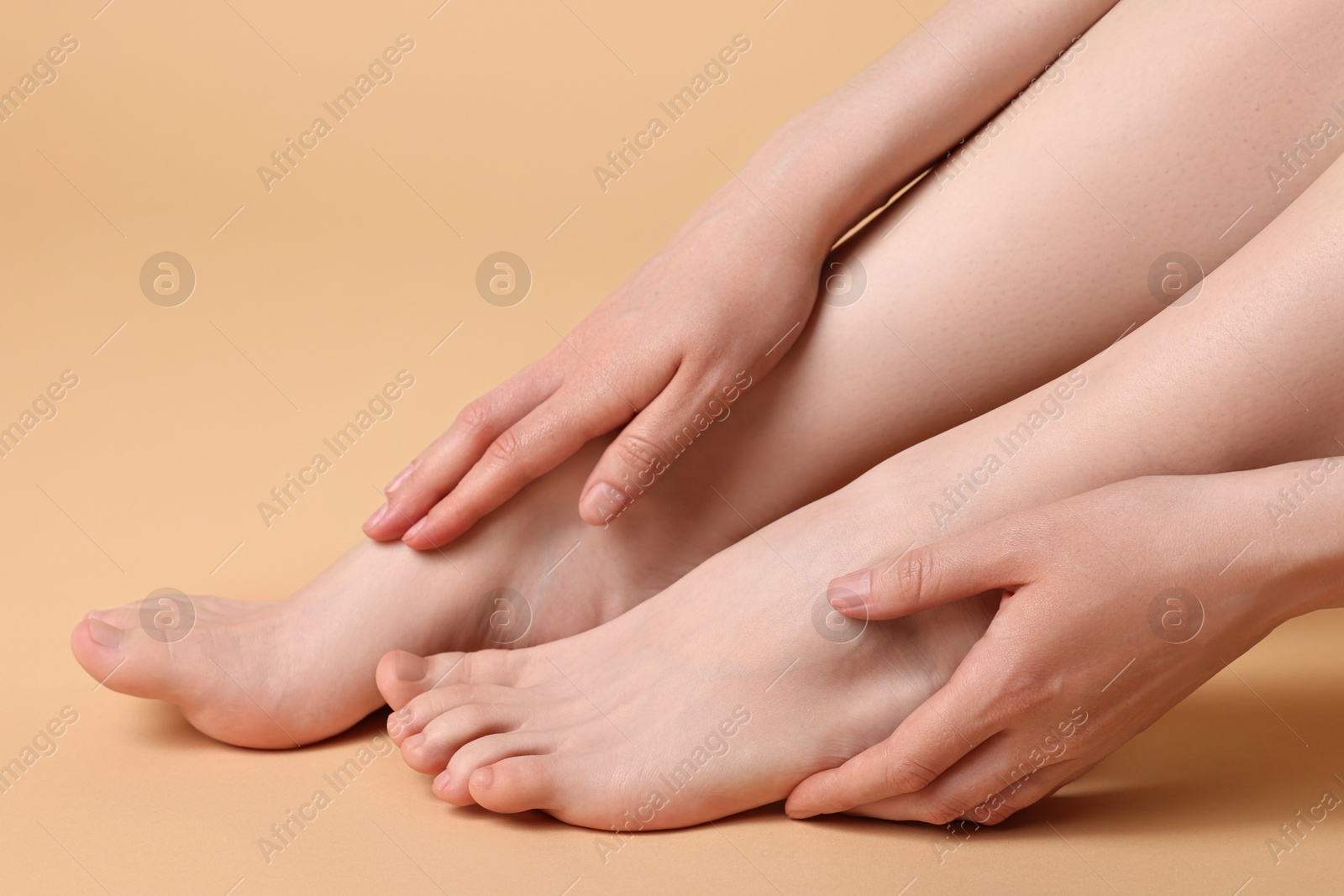 Photo of Closeup view of woman`s groomed feet after care procedure on beige background