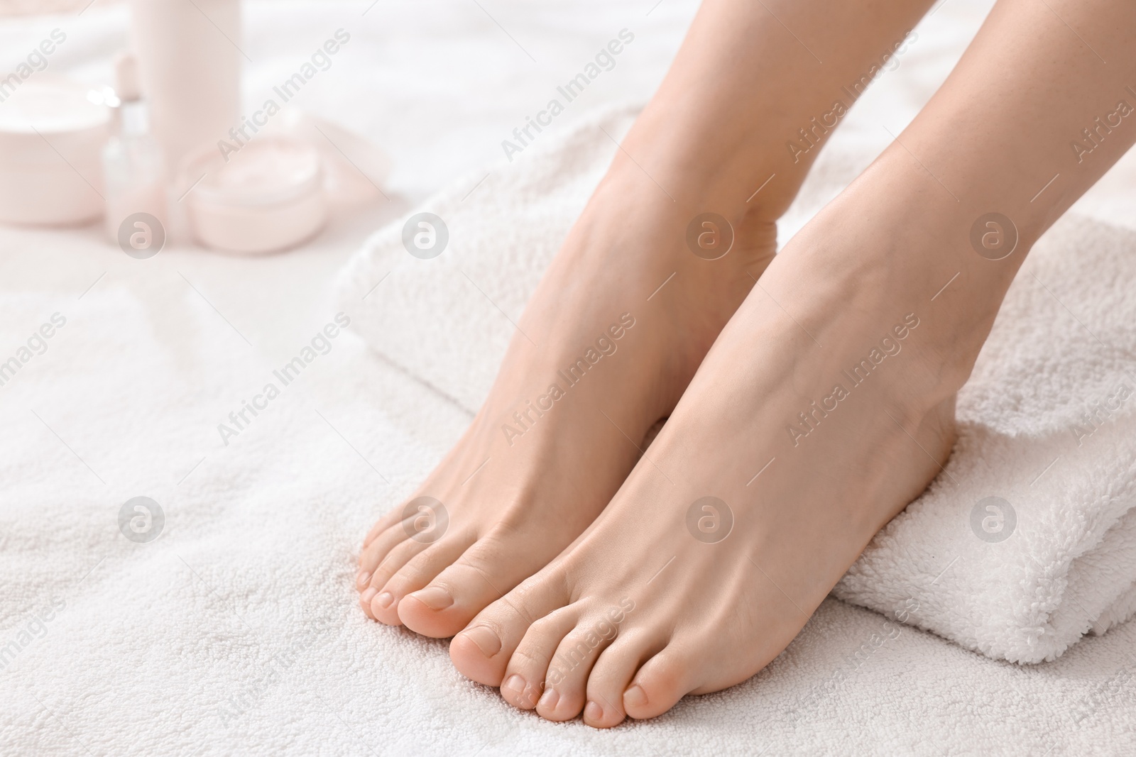 Photo of Closeup view of woman`s groomed feet after care procedure on soft towel