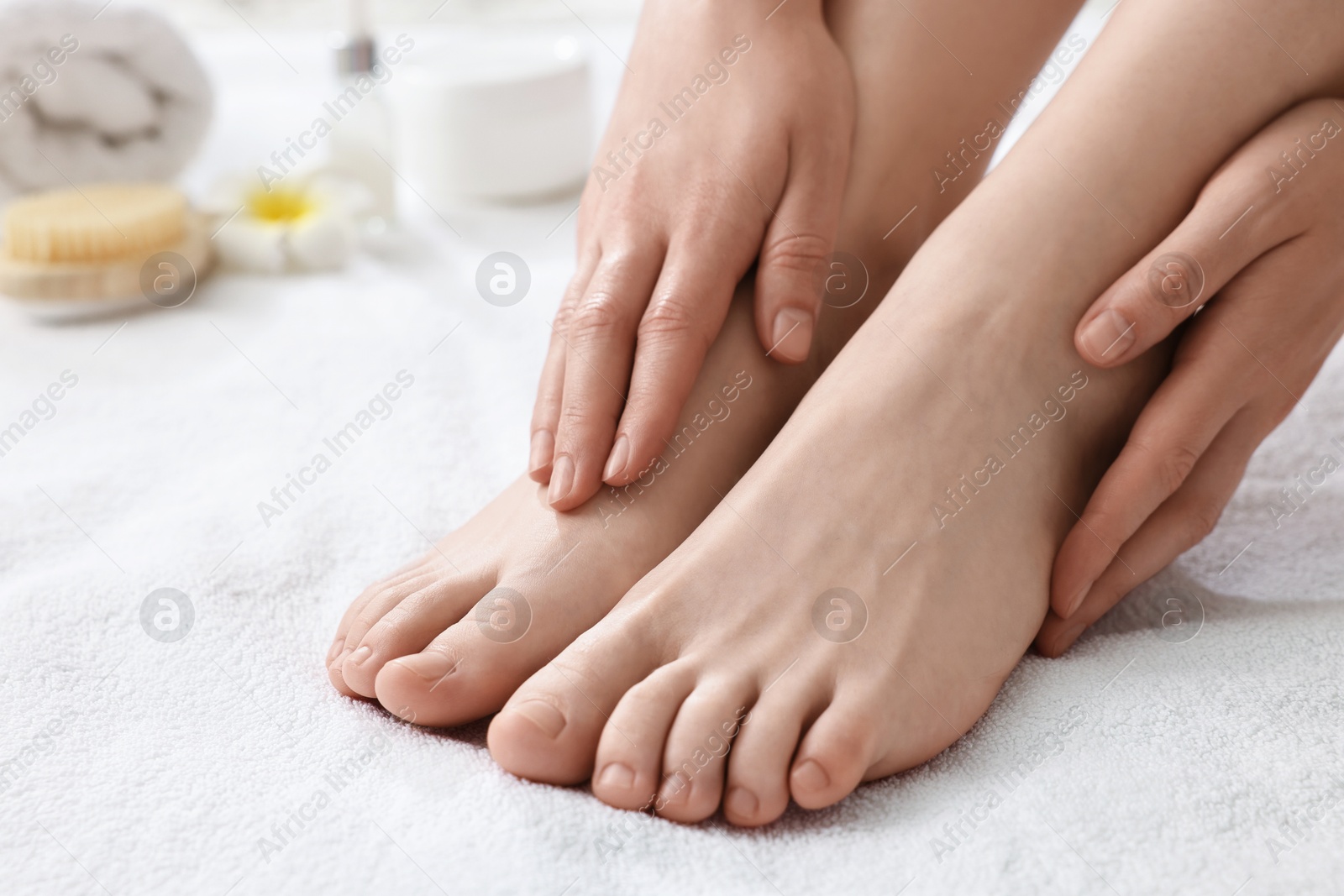 Photo of Closeup view of woman`s groomed feet after care procedure on soft towel