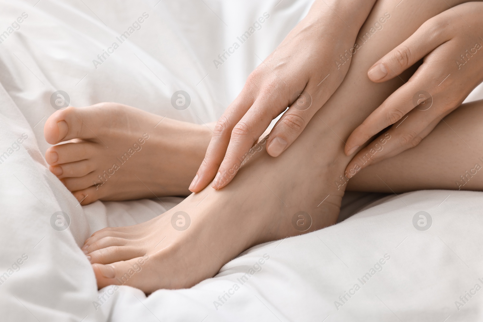 Photo of Closeup view of woman`s groomed feet after care procedure on bed