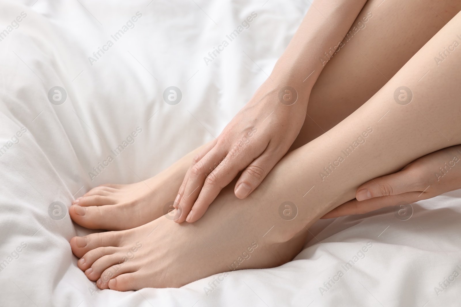 Photo of Closeup view of woman`s groomed feet after care procedure on bed