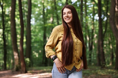 Portrait of smiling woman in forest, space for text. Spring vibes