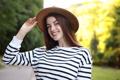 Portrait of smiling woman in hat outdoors. Spring vibes