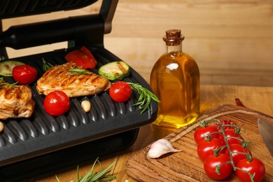 Electric grill with different products on wooden table