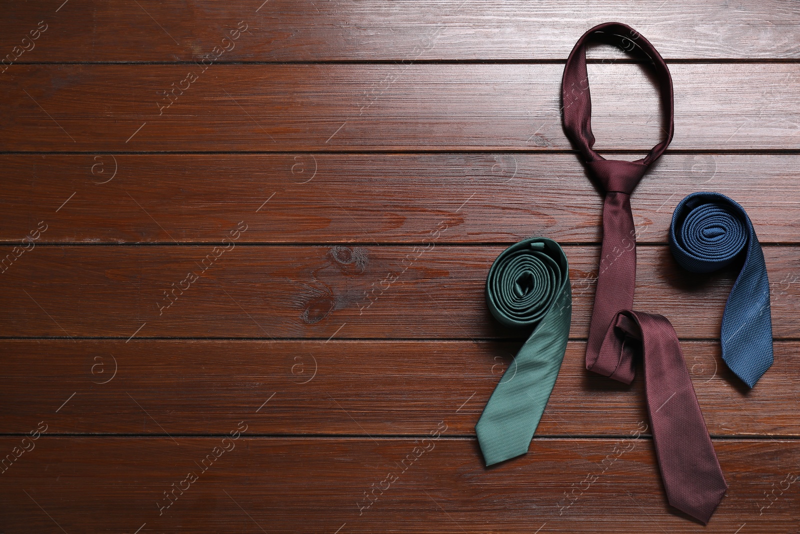 Photo of Different neckties on wooden table, flat lay. Space for text