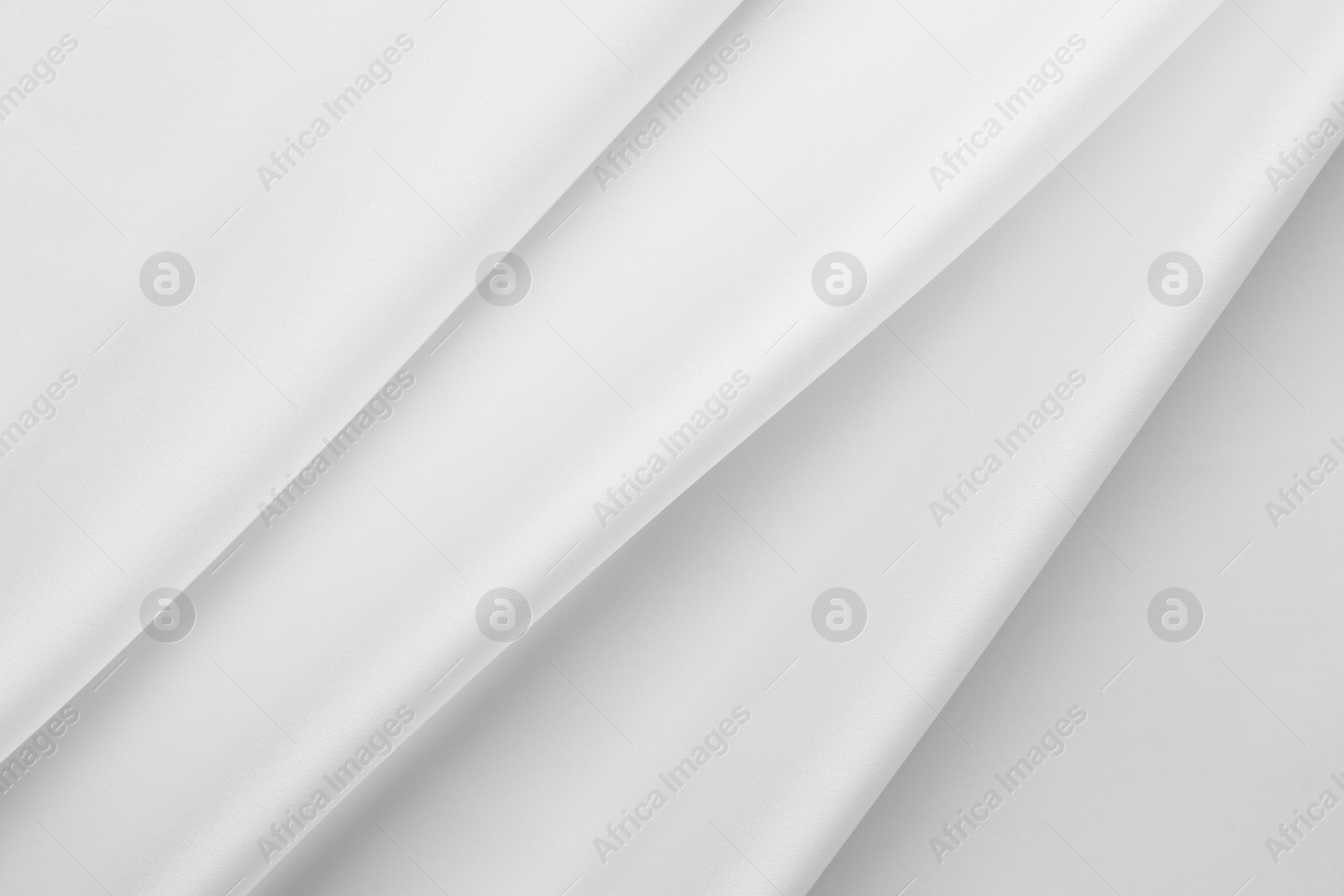 Photo of Texture of crumpled white silk fabric as background, top view