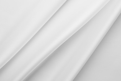 Photo of Texture of crumpled white silk fabric as background, top view