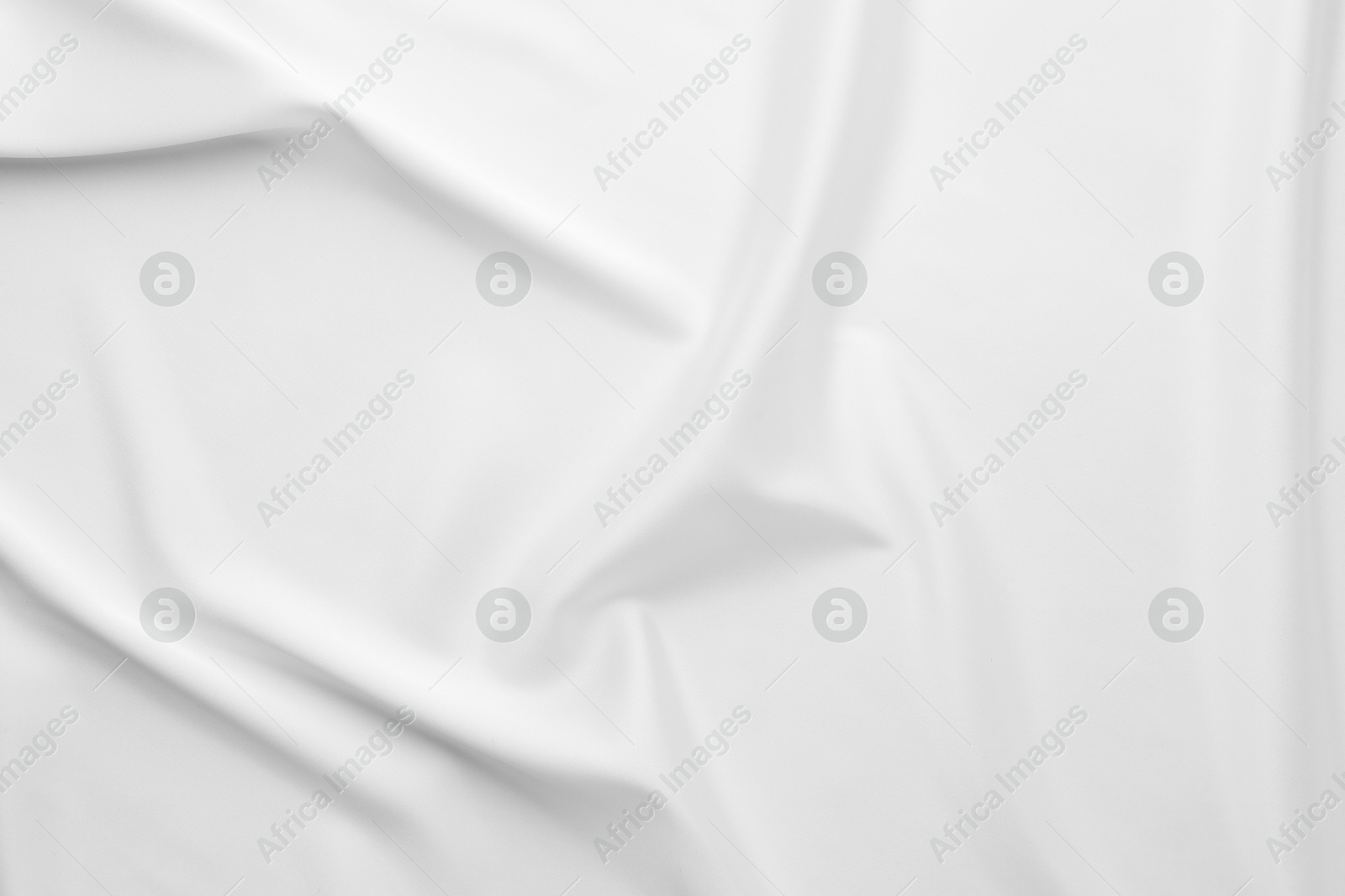 Photo of Texture of crumpled white silk fabric as background, top view