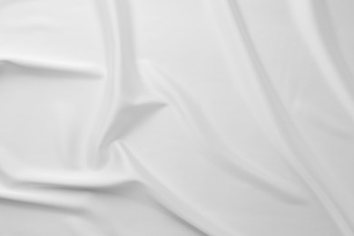 Photo of Texture of crumpled white silk fabric as background, top view