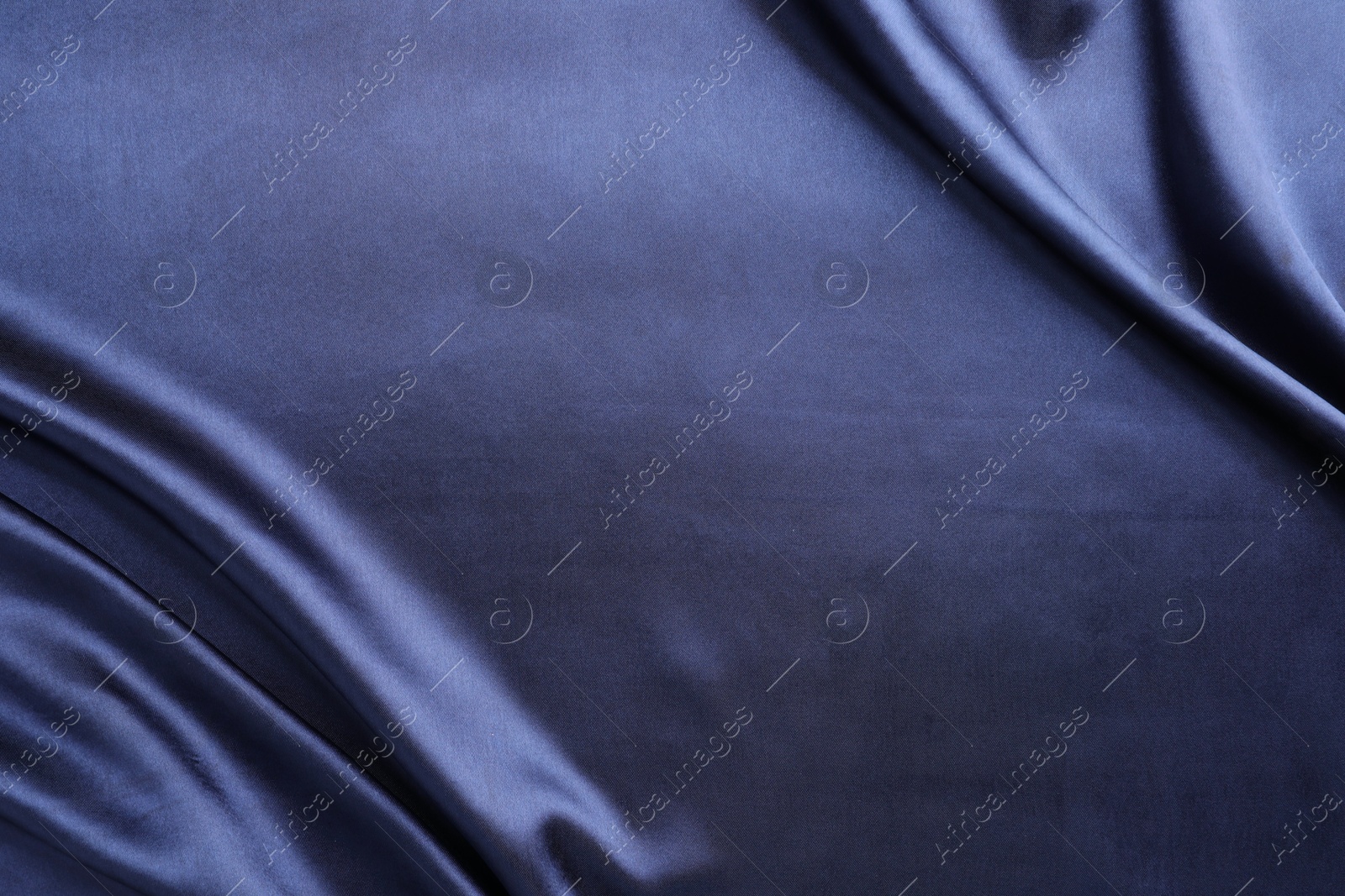 Photo of Crumpled dark blue silk fabric as background, top view. Space for text