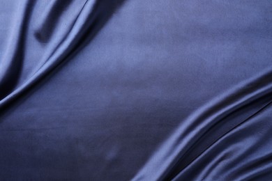 Crumpled dark blue silk fabric as background, top view. Space for text