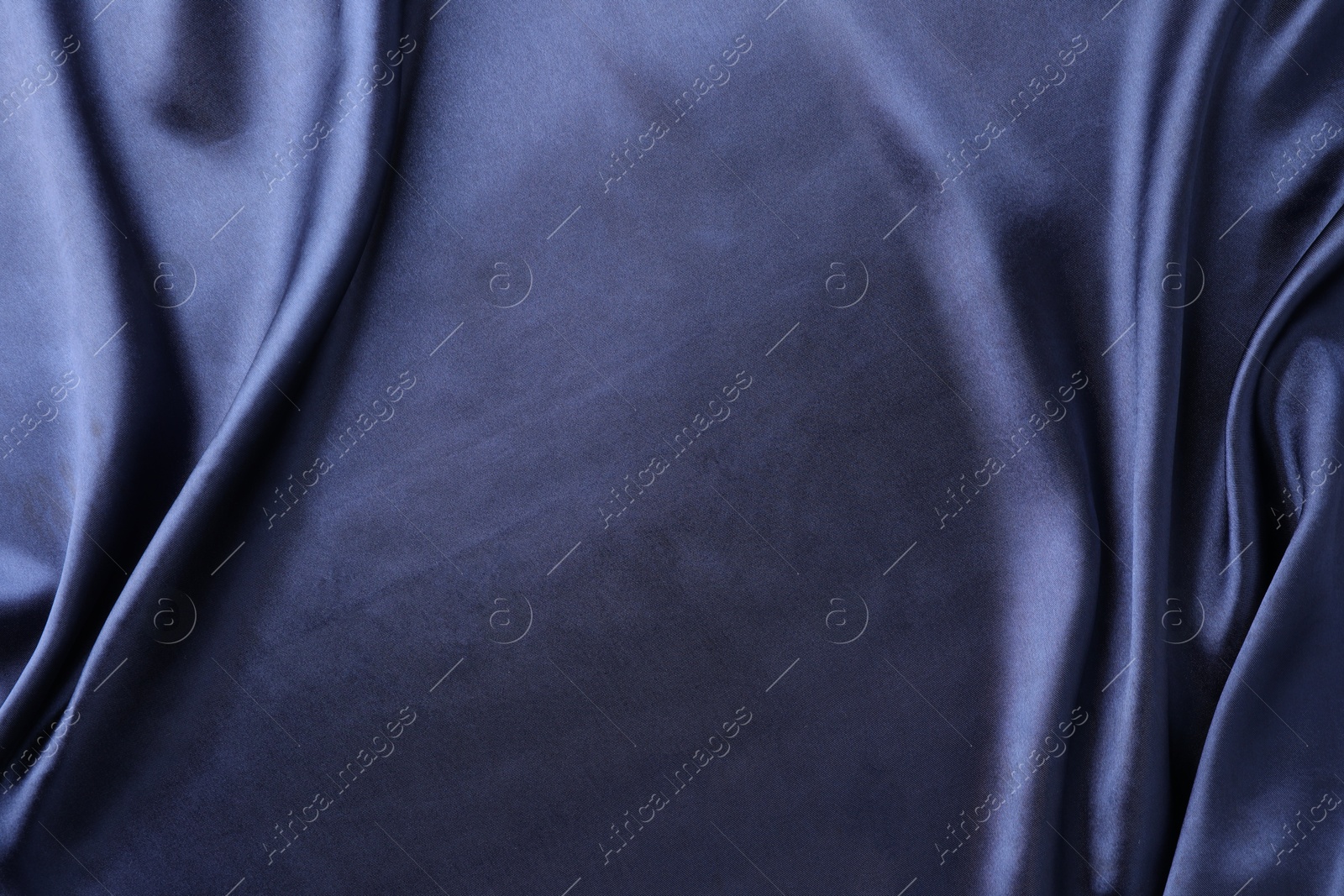 Photo of Crumpled dark blue silk fabric as background, top view. Space for text