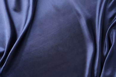 Photo of Crumpled dark blue silk fabric as background, top view. Space for text